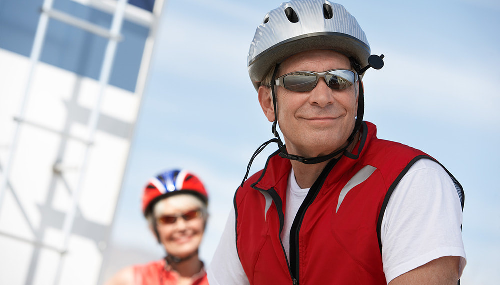 Senior citizen couple biking outdoors - Learn more about the Insurance Products and Services we offer